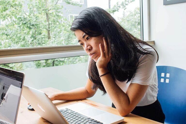 Young Asian woman freelance is working with laptop at coffee shop. Business woman typing, searching and checking document in modern cafe. Working online technology system concept.