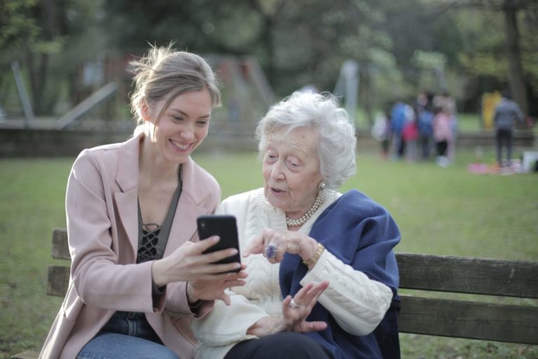 2 women happily looking at a phone