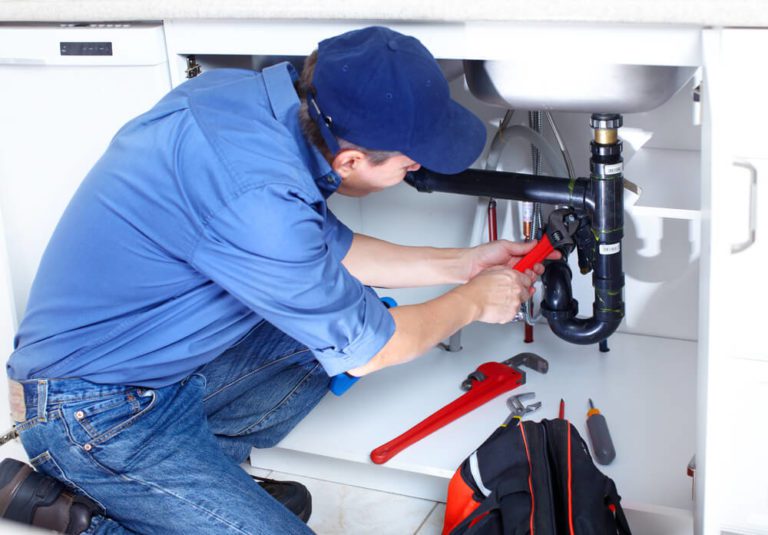 Plumber fixing a kitchen sink