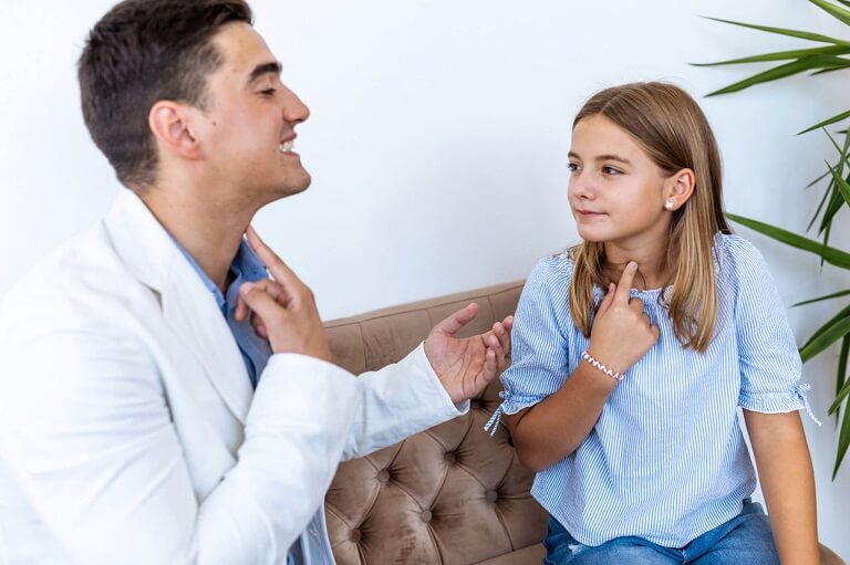 Male speech therapist showing a child patient proper exit point of a letter